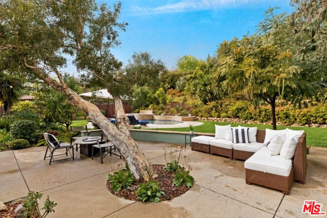 20779 Big Rock Drive Malibu, CA 90265 - Photo 35 of 37 a view of a patio with couches and a table and chairs with wooden floor and fence