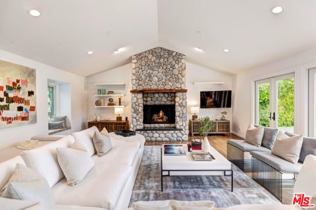 20779 Big Rock Drive Malibu, CA 90265 - Photo 9 of 37 a living room with furniture a large window and a fireplace
