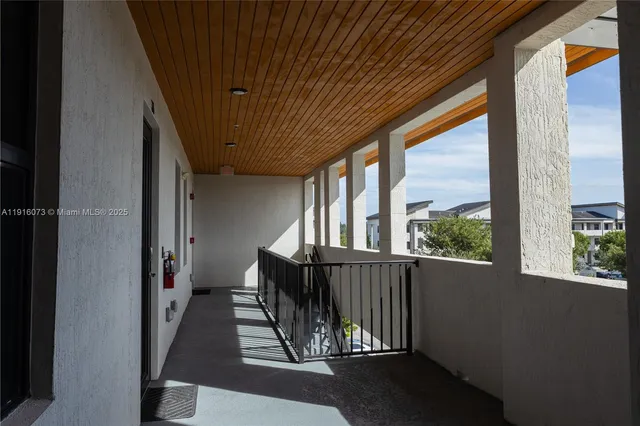 a view of a balcony with wooden floor and iron stairs