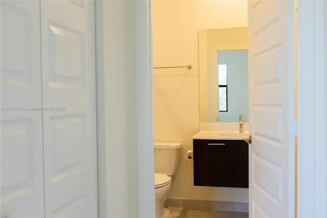 a bathroom with a granite countertop sink and a toilet