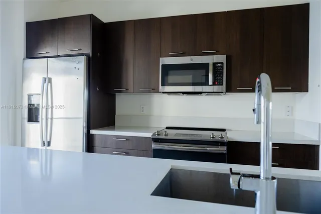 a kitchen with stainless steel appliances a stove microwave and refrigerator