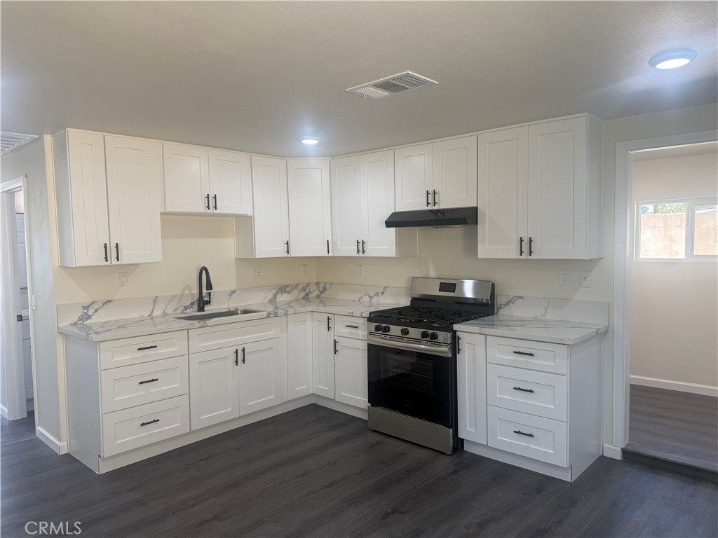 10337 Mull Avenue Riverside, CA 92505 - Photo 4 of 28 a kitchen with granite countertop white cabinets and stainless steel appliances
