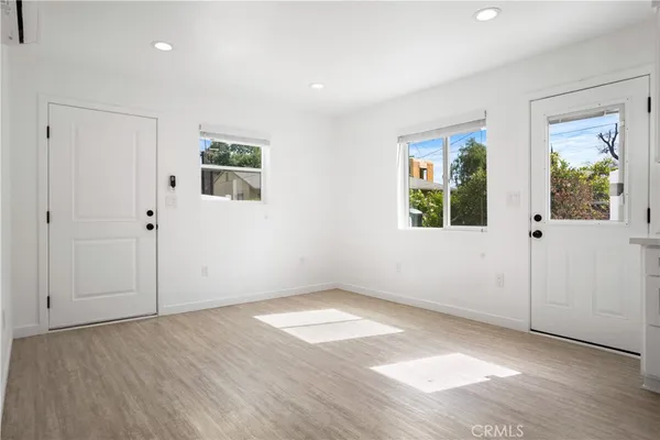 an empty room with wooden floor and windows