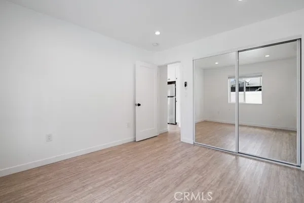 a view of empty room with wooden floor and window