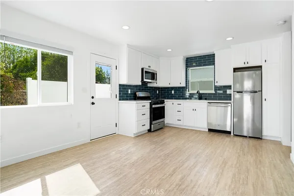 a kitchen with stainless steel appliances a refrigerator sink and microwave