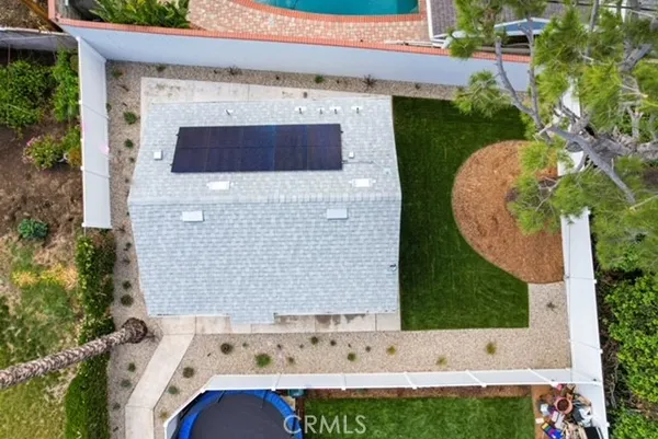 an aerial view of a house with garden space and a swimming pool