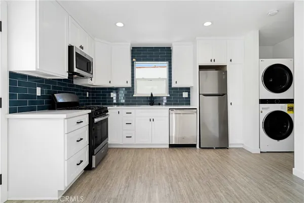 a kitchen with a sink a refrigerator a microwave and cabinets