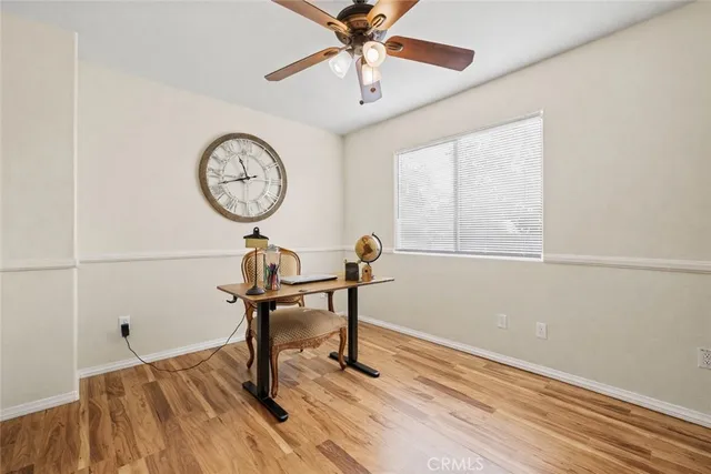 a view of a room with a table a chandelier wooden floor and a window