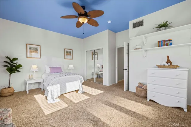 a bedroom with a bed a chandelier and a dresser