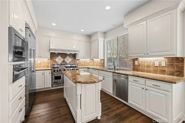 a kitchen with white cabinets sink and stainless steel appliances
