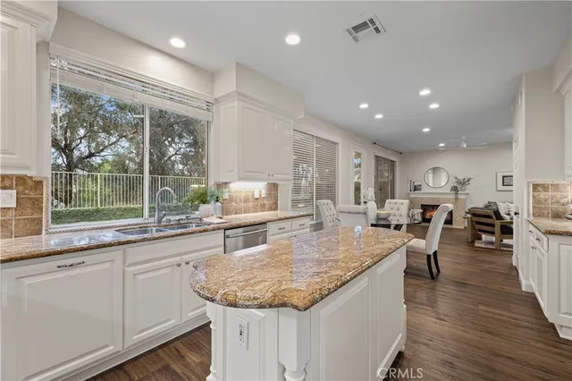 a kitchen with counter top space sink stove and wooden floor