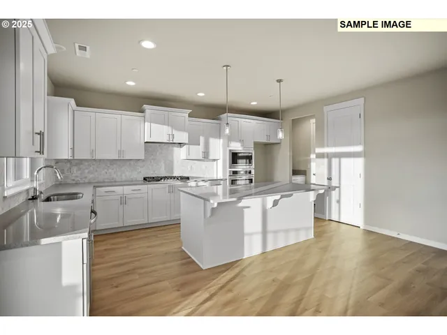 a large kitchen with cabinets wooden floor and stainless steel appliances