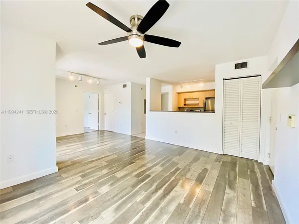 a view of a livingroom with wooden floor and a ceiling fan