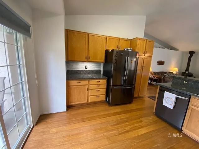 a kitchen with stainless steel appliances granite countertop a refrigerator a stove and a sink