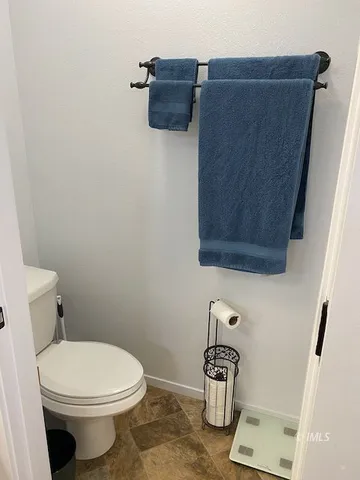 a bathroom with a toilet and a mirror