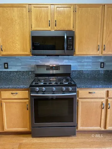 a stove top oven sitting inside of a kitchen