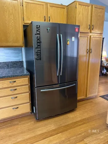 a metallic refrigerator freezer sitting in a kitchen