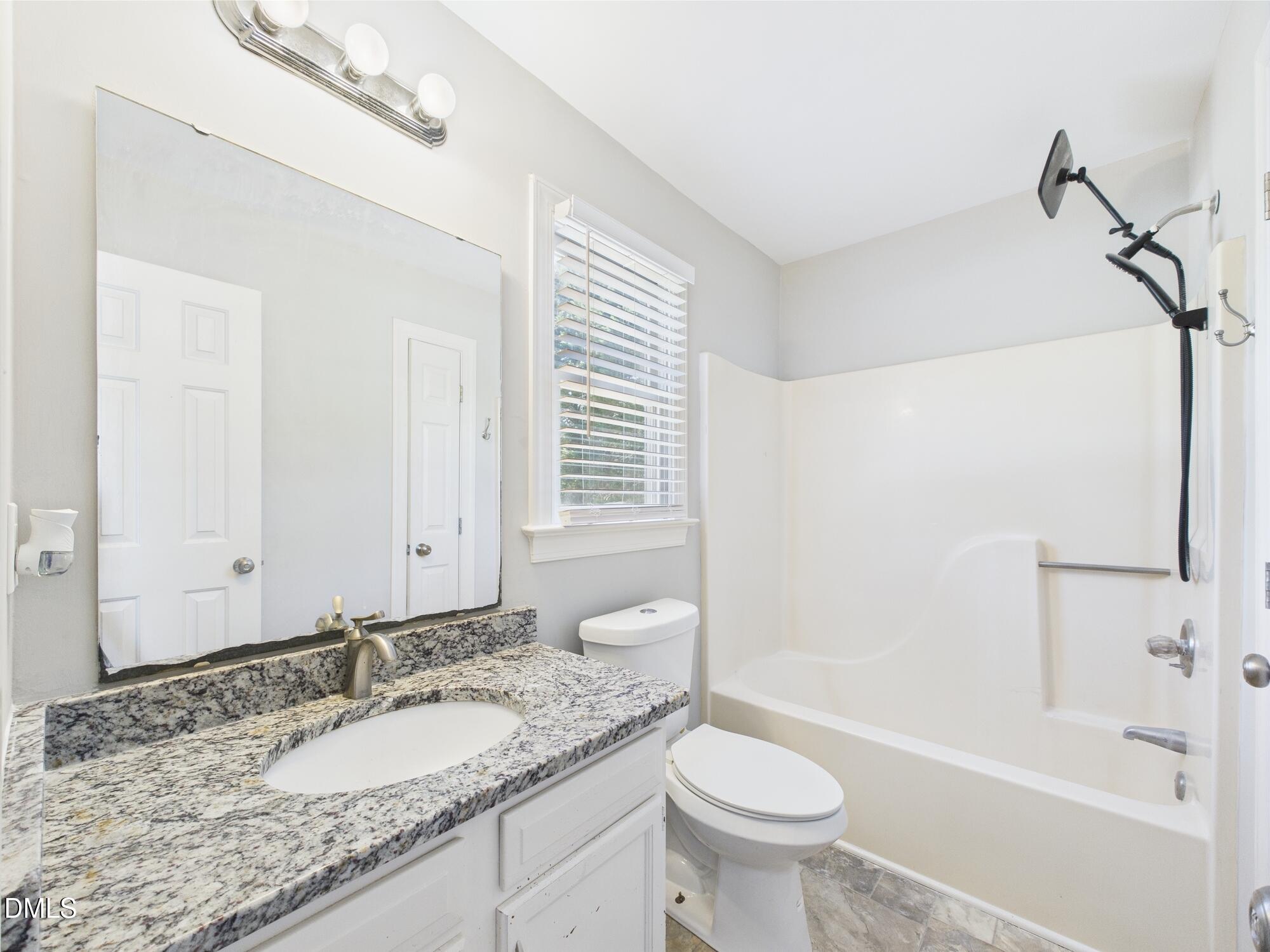 10917 Fanny Brown Road Raleigh, NC 27603 - Photo 29 of 54 a bathroom with a granite countertop sink a toilet and a bathtub