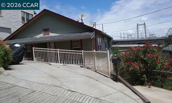 a view of a house with a small yard and flower plants