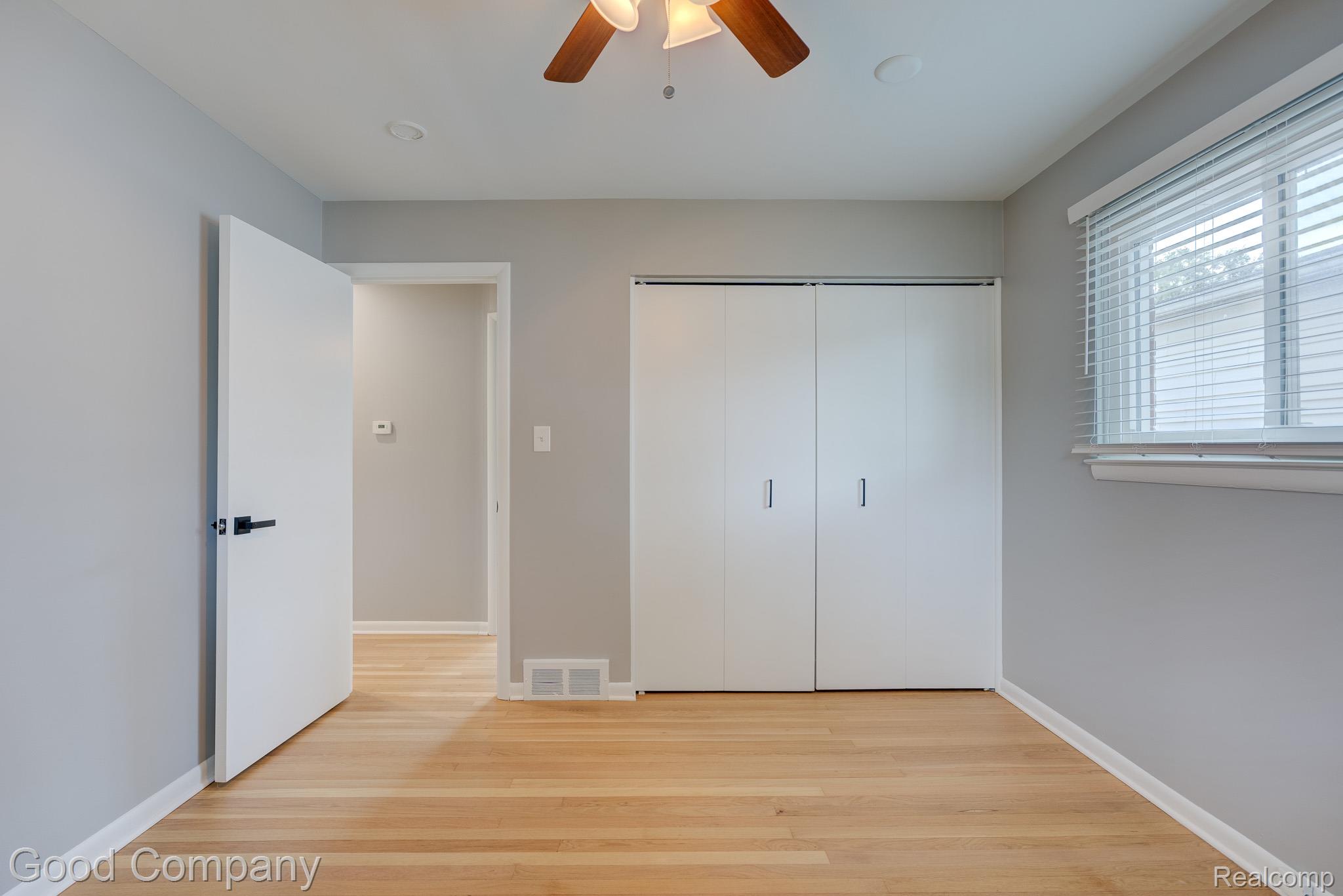 1842 Massoit Road Royal Oak, MI 48073 - Photo 24 of 52 Wood-finish flooring, white bi-fold closet doors, white window blinds, and a ceiling fan with integrated lighting