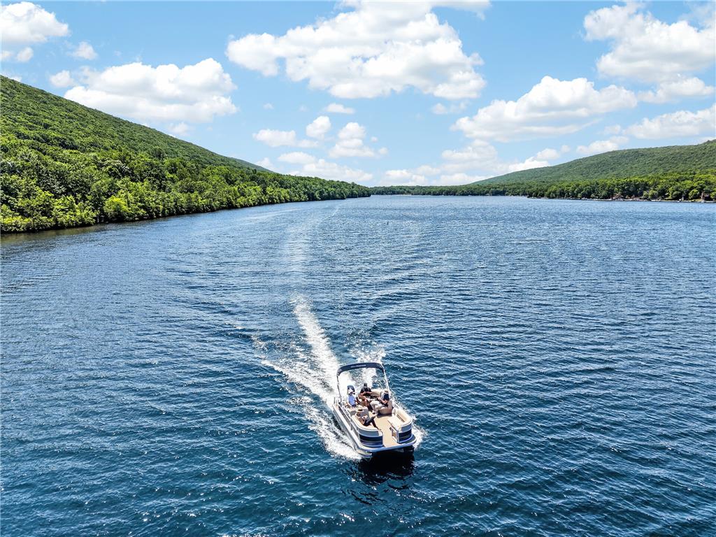 18 White Oak Road Nesquehoning, PA 18240 - Photo 2 of 52 Boating on a tranquil lake, surrounded by verdant hills and a clear sky.
