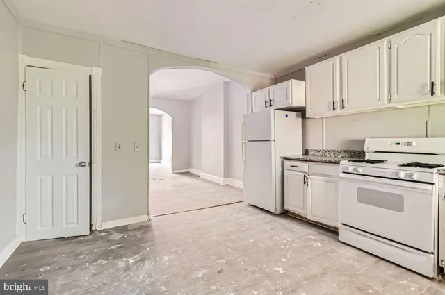 a kitchen with white cabinets and white appliances
