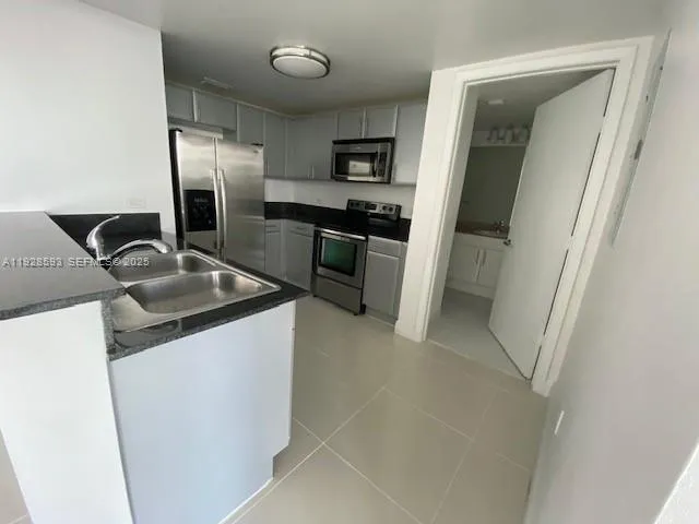 a view of a storage & utility room with refrigerator