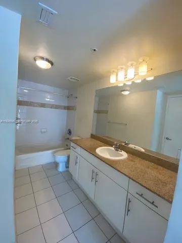 a bathroom with a granite countertop sink a toilet and a mirror