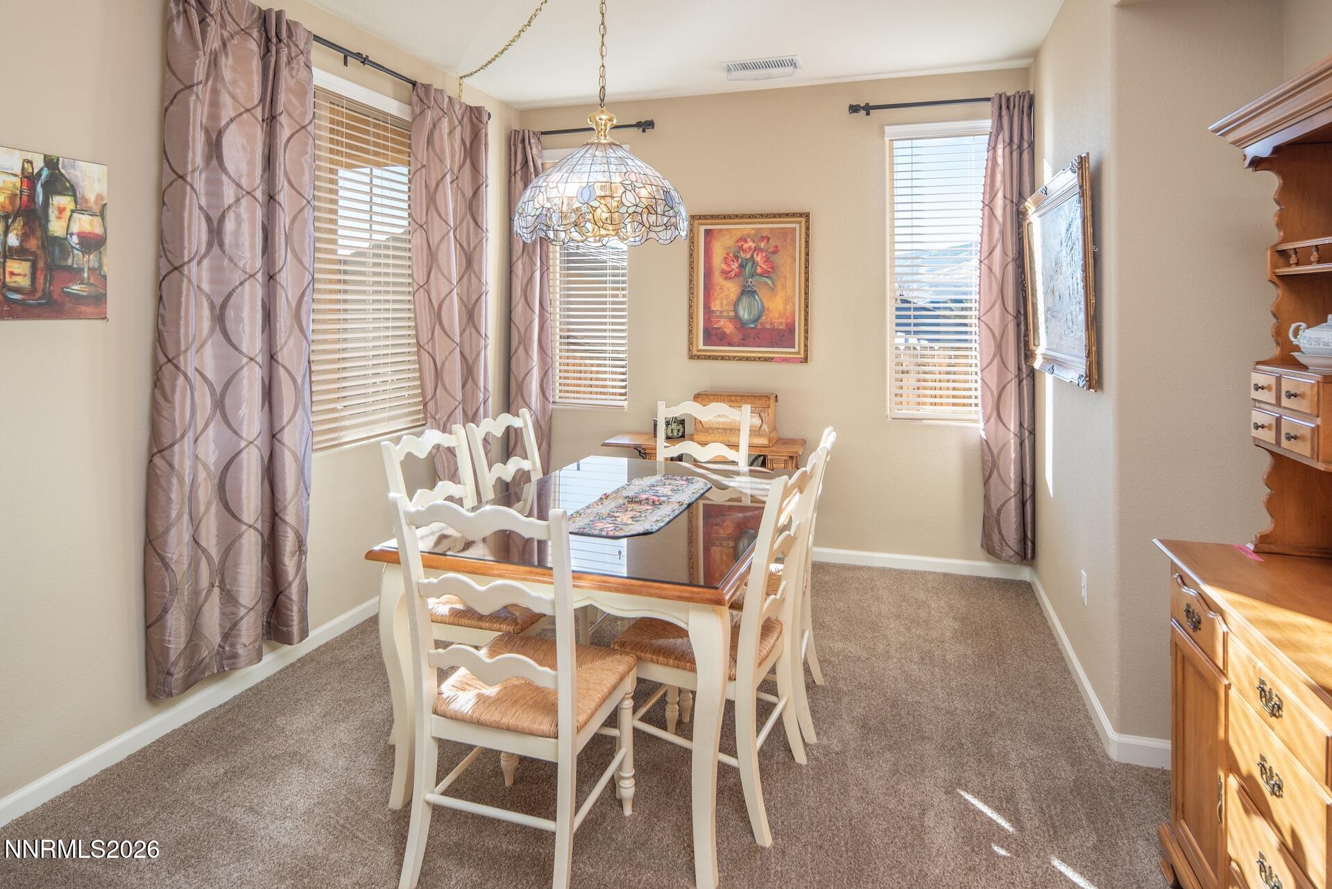 1413 Bluewood Drive Reno, NV 89523 - Photo 14 of 42 a view of a dining room with furniture and a chandelier