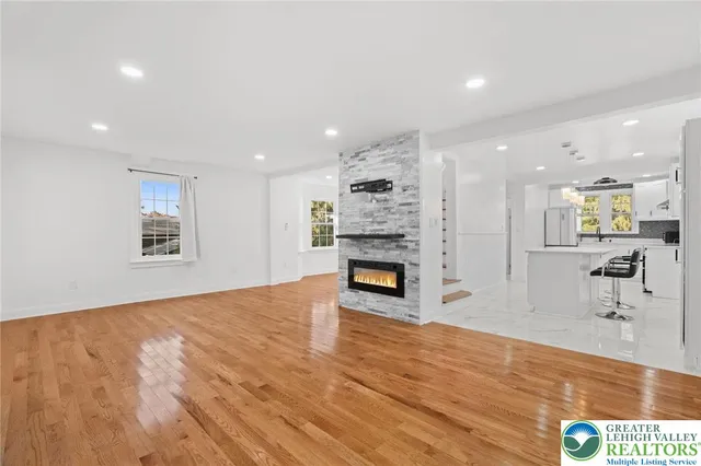 a view of an empty room with a fireplace and wooden floor