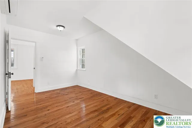 a view of empty room with wooden floor