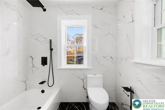 a bathroom with a toilet and a shower