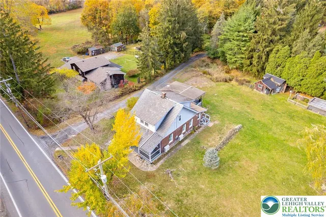 a aerial view of a house with swimming pool and large trees
