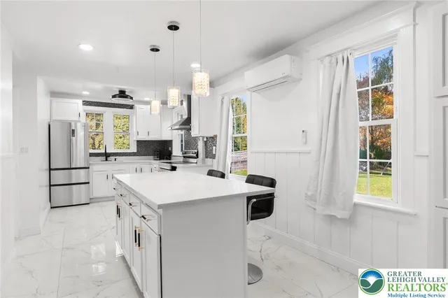 a large white kitchen with cabinets stove top oven and sink