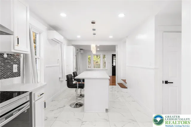 a hallway with a white furniture a rug and a window