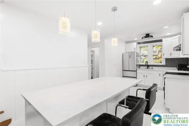 a kitchen with kitchen island a stove and white cabinets