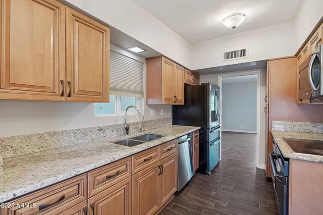 a kitchen with stainless steel appliances granite countertop a sink stove and refrigerator