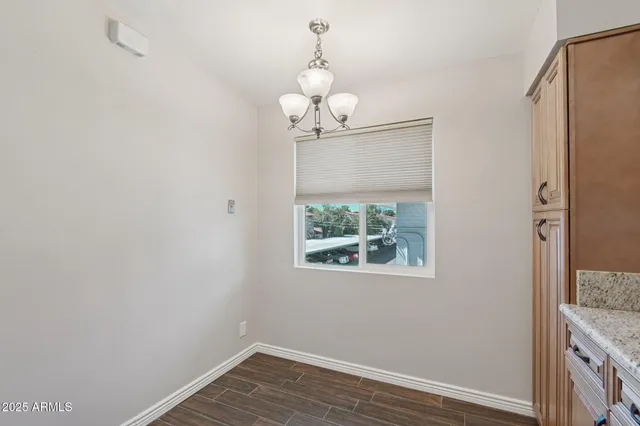 a view of a room with wooden floor chandelier and entryway