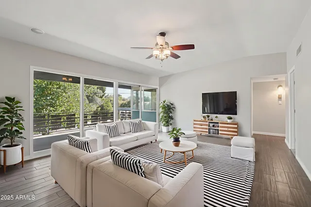 a living room with furniture a flat screen tv and a large window