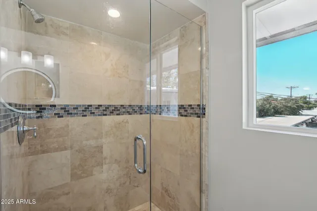 a bathroom with a shower a mirror and a sink