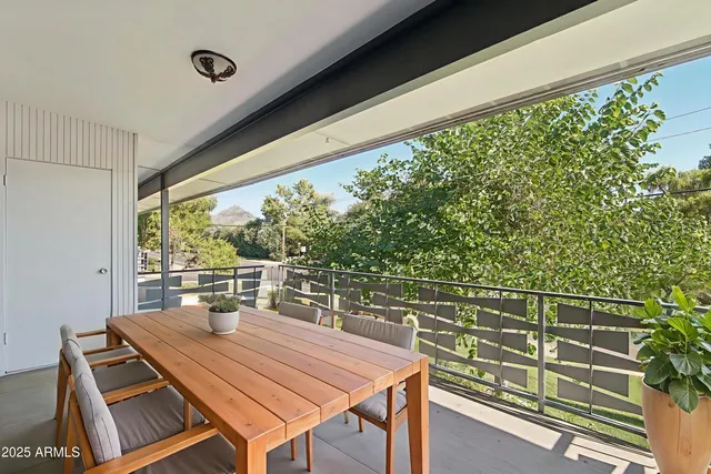 a view of a balcony with table and chairs and wooden floor