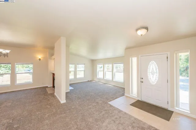 a view of an empty room with a fireplace and a large window