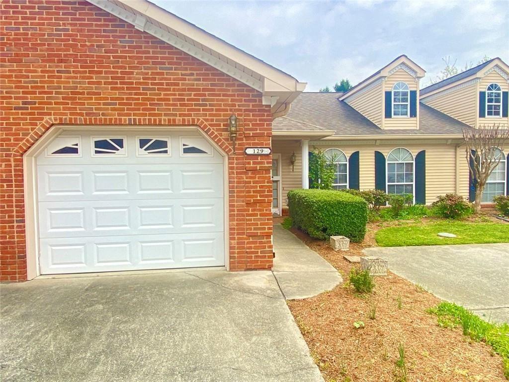 1698 Pin Oak Drive, Unit 129 Dalton, GA 30721 - Photo 2 of 37 a front view of a house with a yard and garage