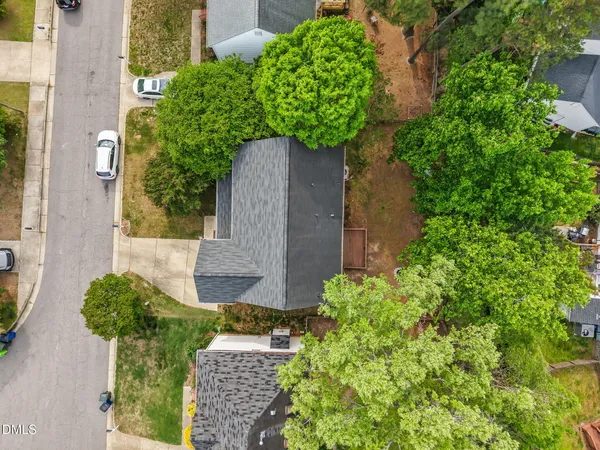 an aerial view of a house with large trees