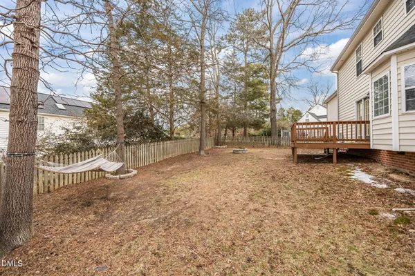 a view of backyard with wooden fence and large trees