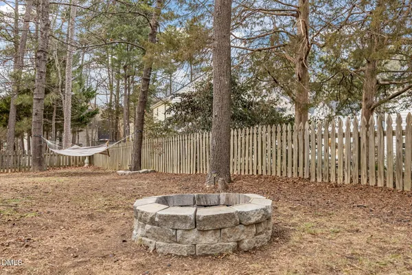 a and white house with a large tree and wooden fence