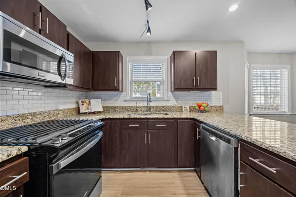 a kitchen with stainless steel appliances a sink stove and microwave