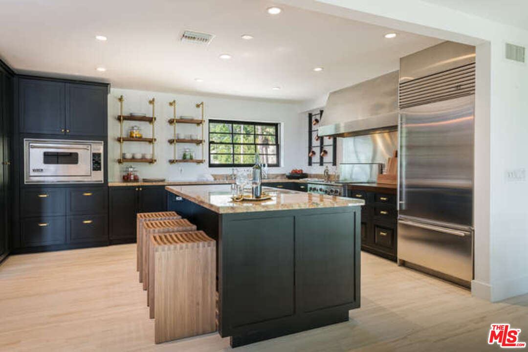 1374 Stradella Road Los Angeles, CA 90077 - Photo 15 of 47 a kitchen with stainless steel appliances granite countertop a sink and a refrigerator