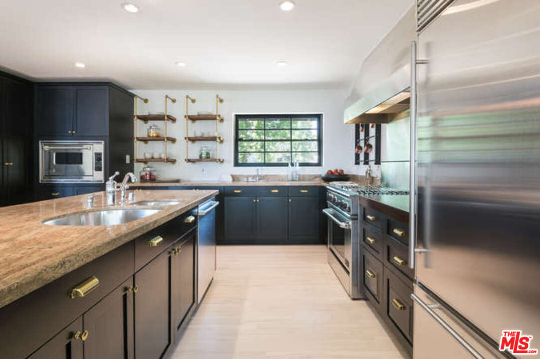 1374 Stradella Road Los Angeles, CA 90077 - Photo 17 of 47 a kitchen with stainless steel appliances granite countertop a sink a stove top oven a counter space and cabinets