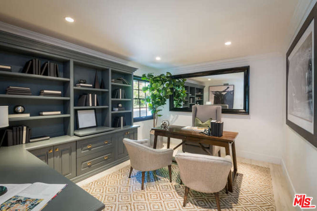 1374 Stradella Road Los Angeles, CA 90077 - Photo 22 of 47 a living room with furniture a rug and a book shelf